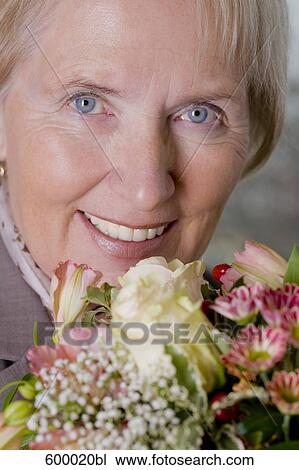 headshot of mature woman holding bunch of roses View Large Photo Image Stock Image - headshot of mature woman holding bunch of roses. Fotosearch