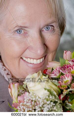 headshot of mature woman holding bunch of roses View Large Photo Image Stock Image - headshot of mature woman holding bunch of roses. Fotosearch