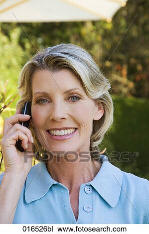 Stock Image - headshot of mature woman talking on mobile phone. Fotosearch