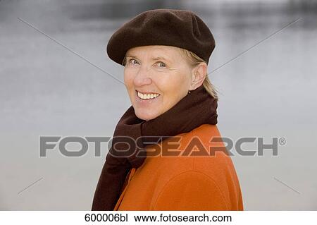 headshot of mature woman wearing brown beret standing at lake in park View Large Photo Image Stock Image - headshot of mature woman wearing brown beret standing at lake in park. Fotosearch