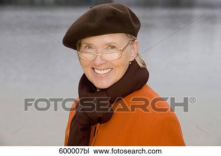 headshot of mature woman wearing brown beret standing at lake in park View Large Photo Image Stock Image - headshot of mature woman wearing brown beret standing at lake in park. Fotosearch