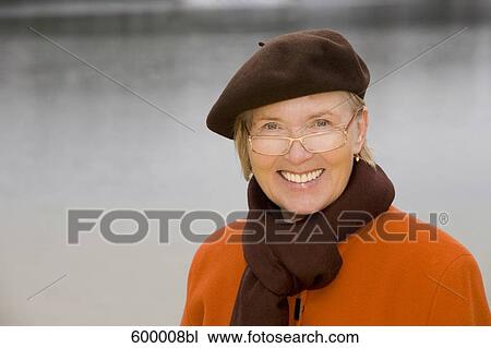 headshot of mature woman wearing brown beret standing at lake in park View Large Photo Image Stock Image - headshot of mature woman wearing brown beret standing at lake in park. Fotosearch