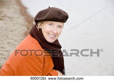 headshot of mature woman wearing brown beret standing at lake in park View Large Photo Image Stock Image - headshot of mature woman wearing brown beret standing at lake in park. Fotosearch