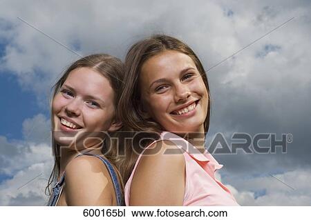 headshot of two smiling young women standing back to back View Large Photo Image Stock Image - headshot of two smiling young women standing back to back. Fotosearch