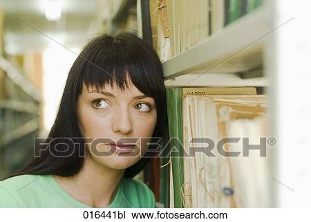 headshot of young female student leaning against bookshelf in school library View Large Photo Image Stock Image - headshot of young female student leaning against bookshelf in school library. Fotosearch