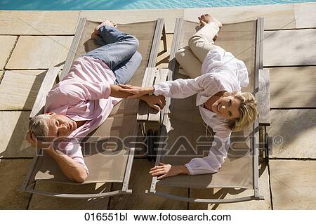high angle portrait of mature couple lying on sun loungers View Large Photo Image Stock Image - high angle portrait of mature couple lying on sun loungers. Fotosearch
