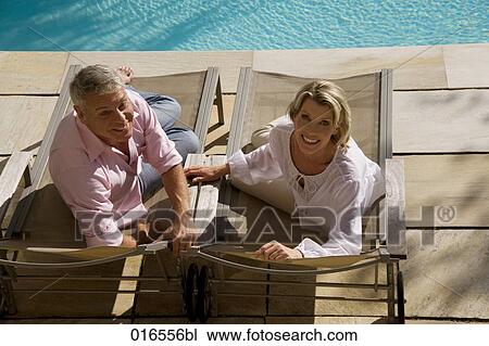 high angle portrait of mature couple lying on sun loungers View Large Photo Image Stock Image - high angle portrait of mature couple lying on sun loungers. Fotosearch