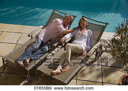 high angle portrait of mature couple lying on sun loungers View Large Photo Image Stock Image - high angle portrait of mature couple lying on sun loungers. Fotosearch