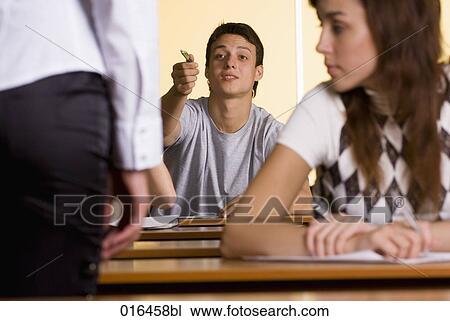 male student giving explanation to teacher during school seminar View Large Photo Image Stock Image - male student giving explanation to teacher during school seminar. Fotosearch