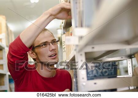 male student with glasses looking for book in school library View Large Photo Image Stock Image - male student with glasses looking for book in school library. Fotosearch