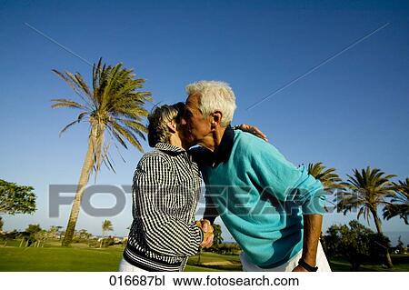 mature couple embracing and shaking hands on golf course View Large Photo Image Stock Image - mature couple embracing and shaking hands on golf course. Fotosearch