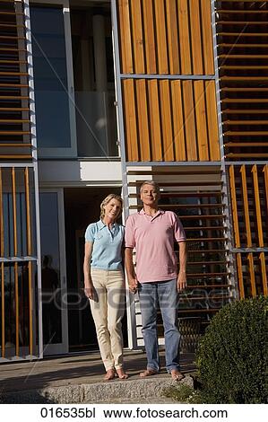 mature couple in front of home holding hands View Large Photo Image Stock Image - mature couple in front of home holding hands. Fotosearch