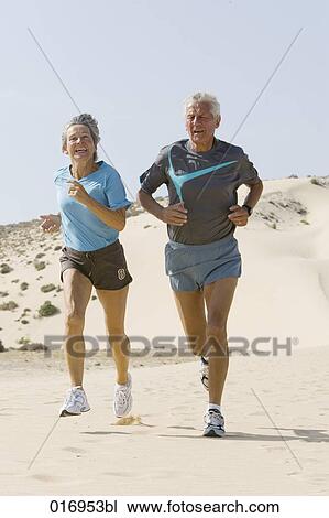 mature couple jogging on sandy beach View Large Photo Image Stock Image - mature couple jogging on sandy beach. Fotosearch