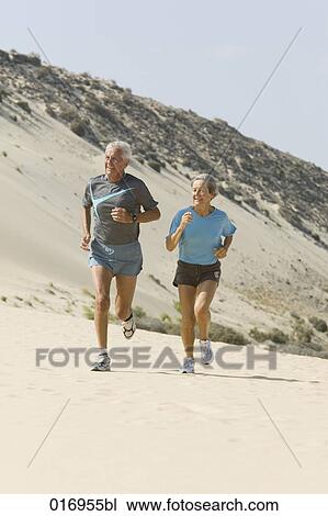 mature couple jogging on sandy beach View Large Photo Image Stock Image - mature couple jogging on sandy beach. Fotosearch