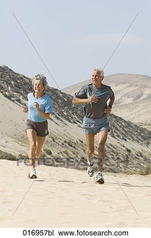 mature couple jogging on sandy beach View Large Photo Image Stock Image - mature couple jogging on sandy beach. Fotosearch