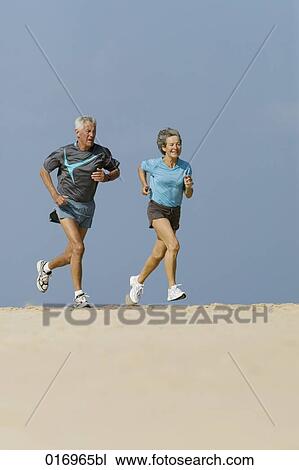 mature couple jogging together on sandy beach View Large Photo Image Stock Image - mature couple jogging together on sandy beach. Fotosearch