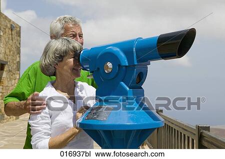 mature couple looking through binocular View Large Photo Image Stock Image - mature couple looking through binocular. Fotosearch