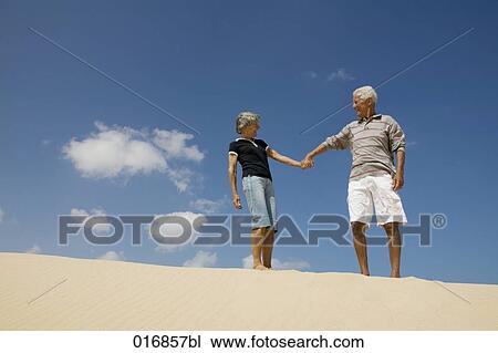 mature couple on beach holding hands and looking at each other View Large Photo Image Stock Image - mature couple on beach holding hands and looking at each other. Fotosearch