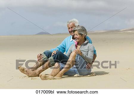 mature couple relaxing on beach together View Large Photo Image Stock Image - mature couple relaxing on beach together. Fotosearch