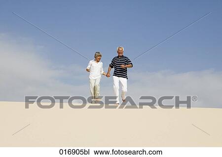 mature couple running down beach hand in hand View Large Photo Image Stock Image - mature couple running down beach hand in hand. Fotosearch