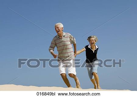 mature couple running on beach hand in hand View Large Photo Image Stock Image - mature couple running on beach hand in hand. Fotosearch