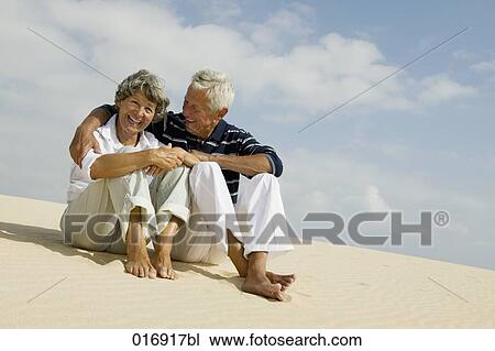 mature couple sitting on beach together View Large Photo Image Stock Image - mature couple sitting on beach together. Fotosearch