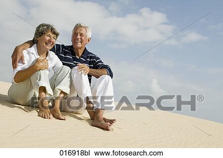mature couple sitting on beach together View Large Photo Image Stock Image - mature couple sitting on beach together. Fotosearch