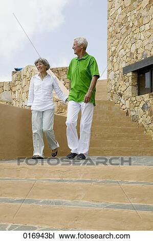 mature couple walking down stairs hand in hand View Large Photo Image Stock Image - mature couple walking down stairs hand in hand. Fotosearch