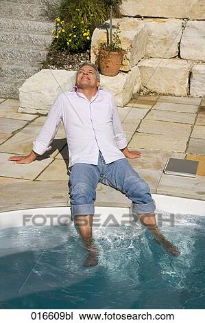 mature man enjoying the sun near swimming pool View Large Photo Image Stock Image - mature man enjoying the sun near swimming pool. Fotosearch