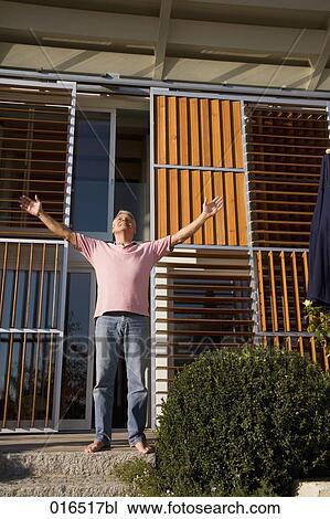 mature man in front of his home enjoying the first rays of sun View Large Photo Image Stock Image - mature man in front of his home enjoying the first rays of sun. Fotosearch