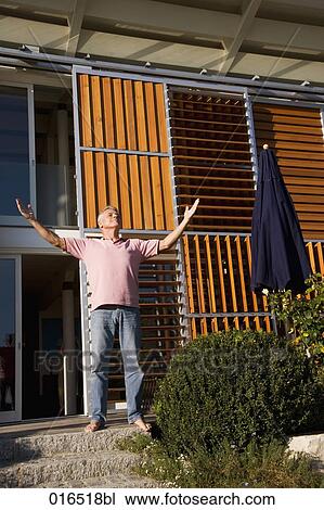 mature man in front of his home enjoying the first rays of sun View Large Photo Image Stock Image - mature man in front of his home enjoying the first rays of sun. Fotosearch