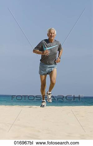 mature man jogging on sandy beach View Large Photo Image Stock Image - mature man jogging on sandy beach. Fotosearch