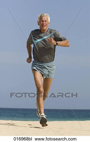 mature man jogging on sandy beach View Large Photo Image Stock Image - mature man jogging on sandy beach. Fotosearch