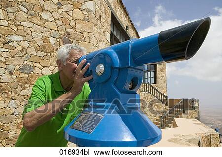 mature man looking through binocular View Large Photo Image Stock Image - mature man looking through binocular. Fotosearch