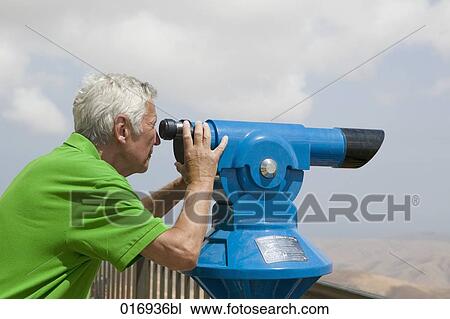 mature man looking through binocular View Large Photo Image Stock Image - mature man looking through binocular. Fotosearch