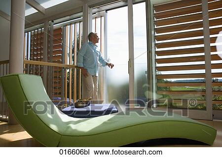 mature man standing in living room looking out of window View Large Photo Image Stock Image - mature man standing in living room looking out of window . Fotosearch