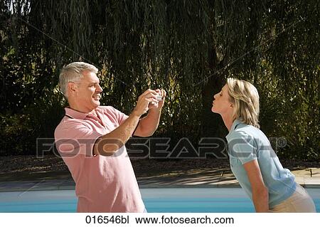 mature man taking portrait of wife with digital camera in front of swimming pool View Large Photo Image Stock Image - mature man taking portrait of wife with digital camera in front of swimming pool. Fotosearch