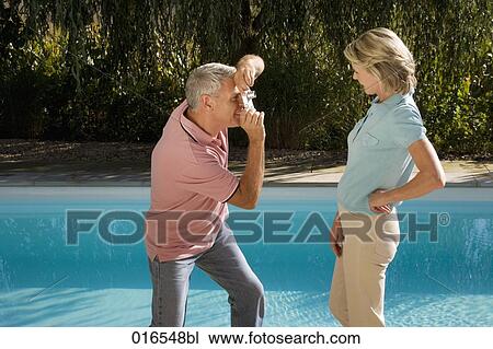 mature man taking portrait of wife with digital camera in front of swimming pool View Large Photo Image Stock Image - mature man taking portrait of wife with digital camera in front of swimming pool. Fotosearch