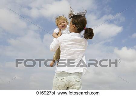 Stock Image - mother hugging her young son. Fotosearch