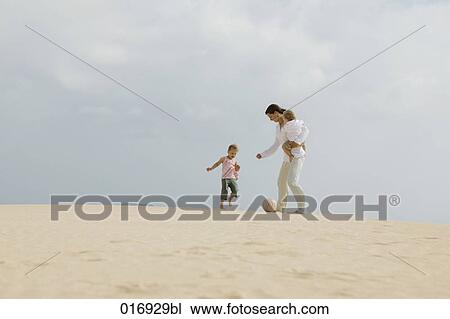 Stock Image - mother playing football with her children. Fotosearch