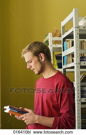 pensive student standing at bookshelf in library View Large Photo Image Stock Image - pensive student standing at bookshelf in library. Fotosearch