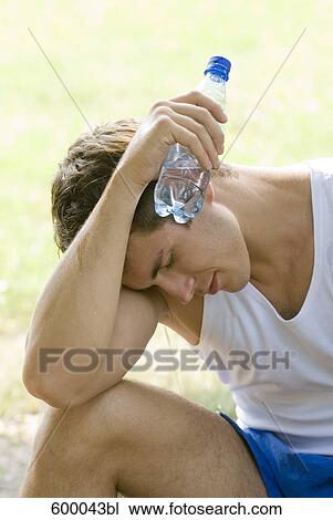 portrait of exhausted young man holding water bottle View Large Photo Image Stock Image - portrait of exhausted young man holding water bottle. Fotosearch