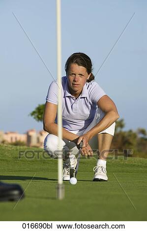 portrait of female golf player kneeling by hole on putting green View Large Photo Image Stock Image - portrait of female golf player kneeling by hole on putting green. Fotosearch