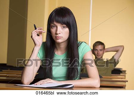 Stock Image - portrait of female student holding pencil. Fotosearch