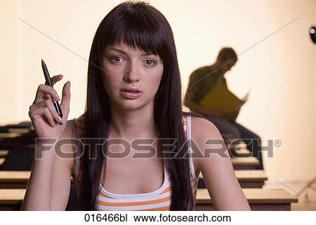 Stock Image - portrait of female student holding pencil. Fotosearch