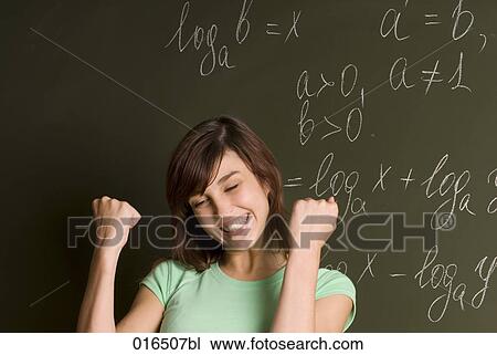 Stock Image - portrait of happy female student in front of blackboard. Fotosearch