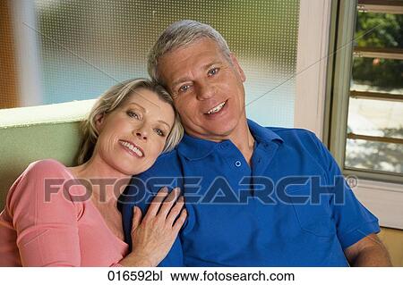portrait of mature couple sitting on sofa at home View Large Photo Image Stock Image - portrait of mature couple sitting on sofa at home. Fotosearch