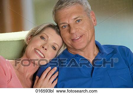 portrait of mature couple sitting on sofa at home View Large Photo Image Stock Image - portrait of mature couple sitting on sofa at home. Fotosearch