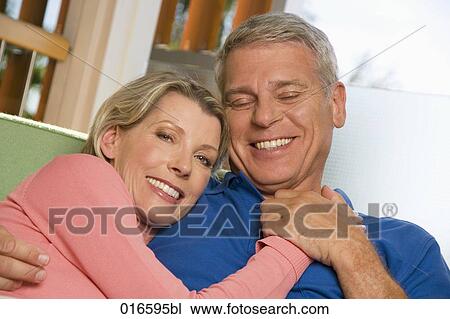 portrait of mature couple sitting on sofa at home View Large Photo Image Stock Image - portrait of mature couple sitting on sofa at home. Fotosearch