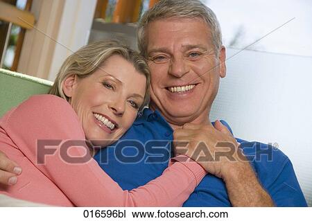 portrait of mature couple sitting on sofa at home View Large Photo Image Stock Image - portrait of mature couple sitting on sofa at home. Fotosearch